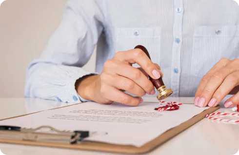 Woman finalizing visa cancellation in UAE with a stamp on document.