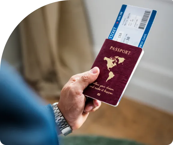 Close-up of a hand holding a passport with flight ticket, ready for visa cancellation in UAE.