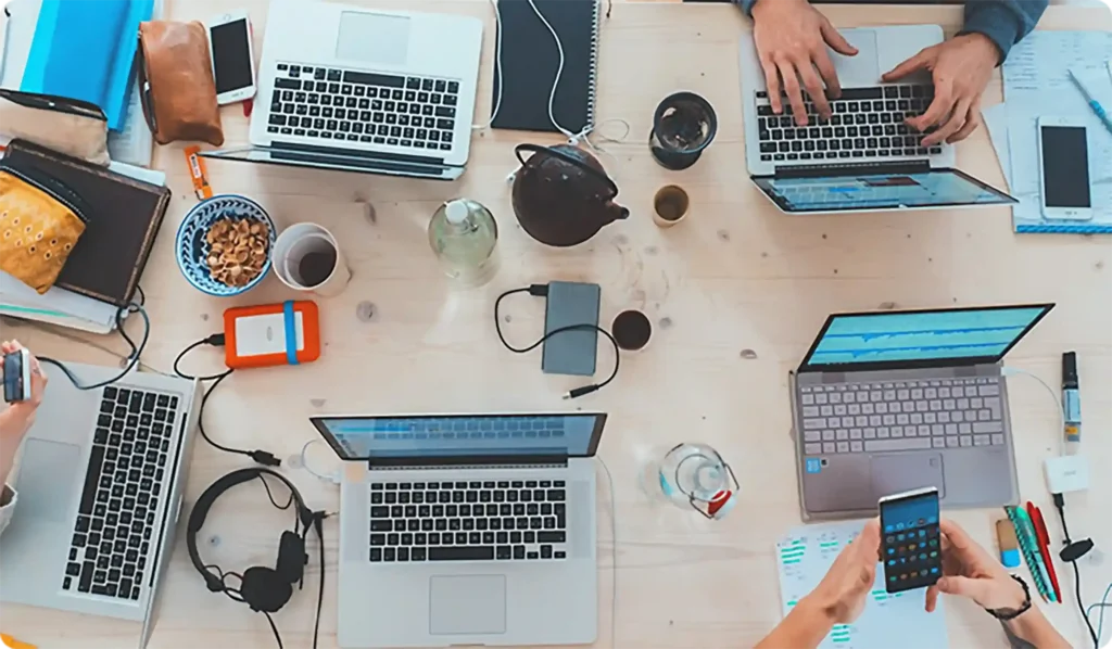 Best typing center team workspace with multiple laptops and documents