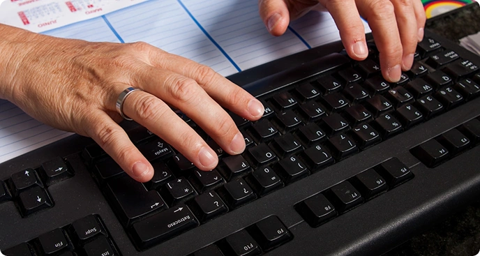 Hands typing on black keyboard for professional best typing services